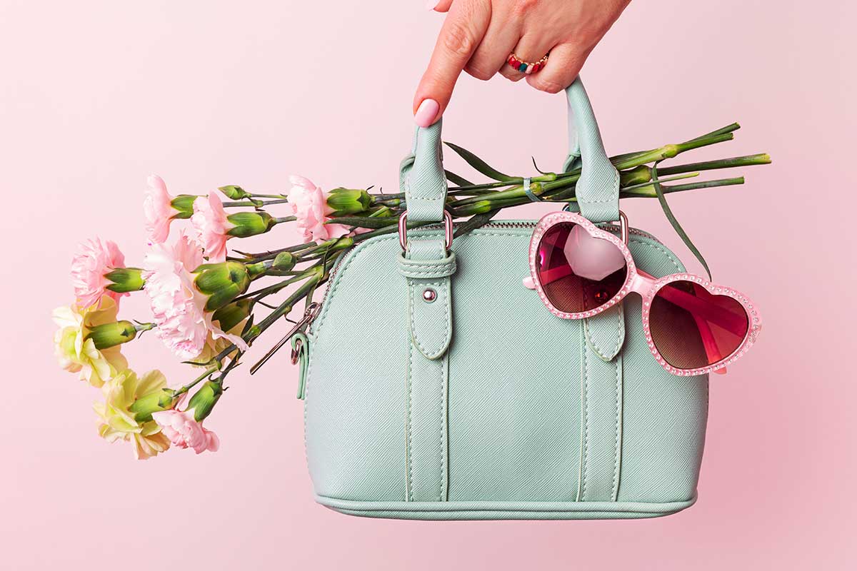 styled handbag product with bouquet of flowers